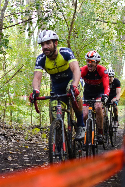 a group of bikers riding down a trail