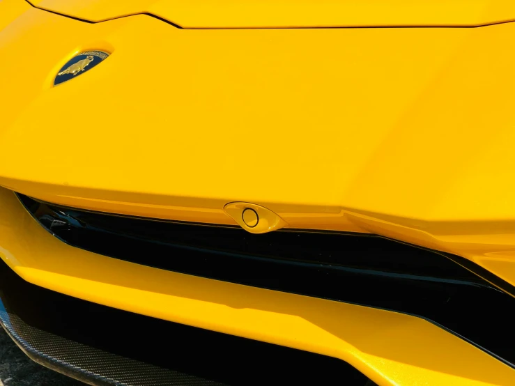 the front end of a yellow car parked