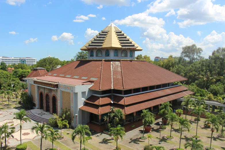 a building with a roof that is standing in the middle of some trees