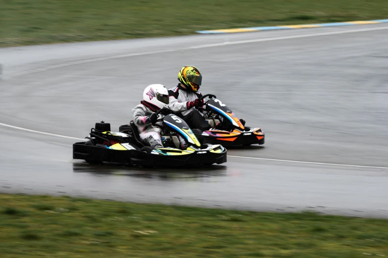 two people racing on karting vehicles on a track