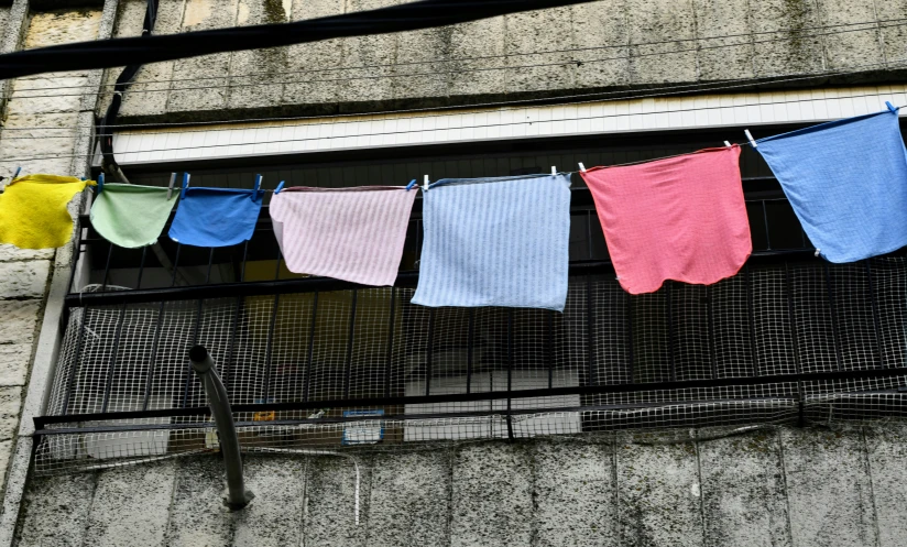 colored cloths hanging from a building on a wire