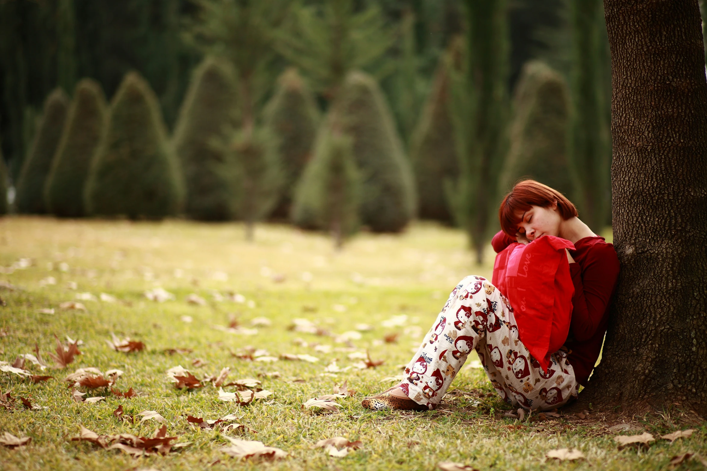 a woman in the park is holding on to a tree