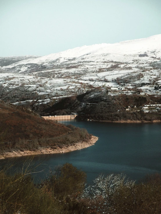 a snowy mountain range overlooks a large body of water