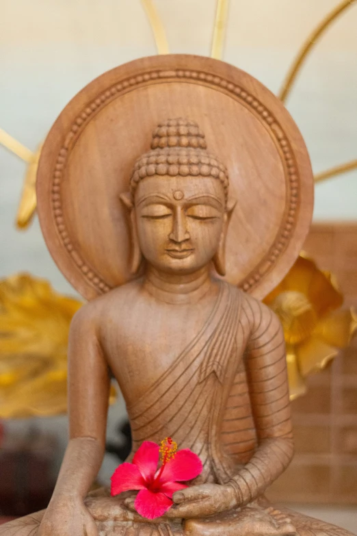 a statue of buddha holding a flower in its hands