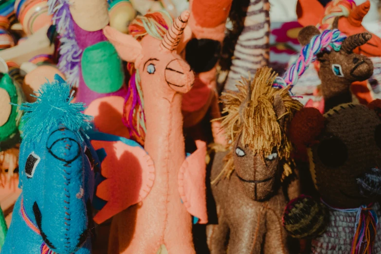 several colorful stuffed animals are lined up against a wall