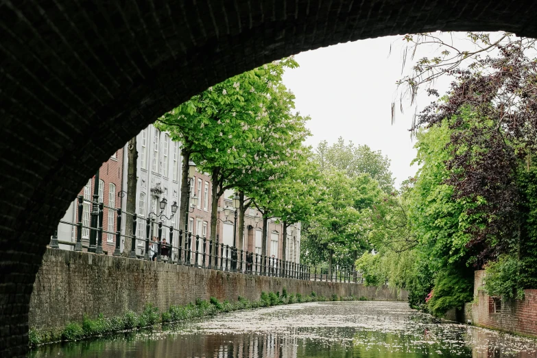 an arched passage at the end of a narrow waterway with water underneath it