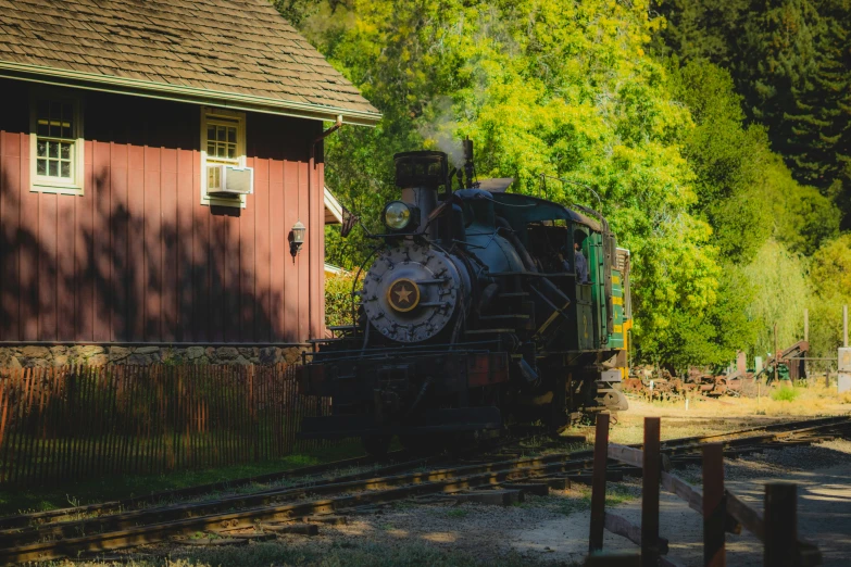 a small train on the tracks near a house