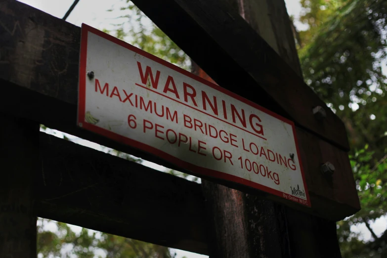 the signs on the wooden fence say maximum bridge load ahead