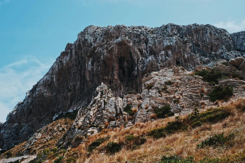 a mountain with brown grass and grass in front