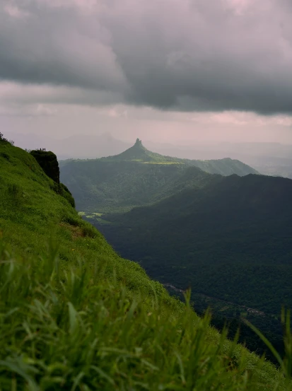 green hillside with many mountains and grass in the foreground