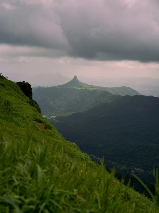 green hillside with many mountains and grass in the foreground