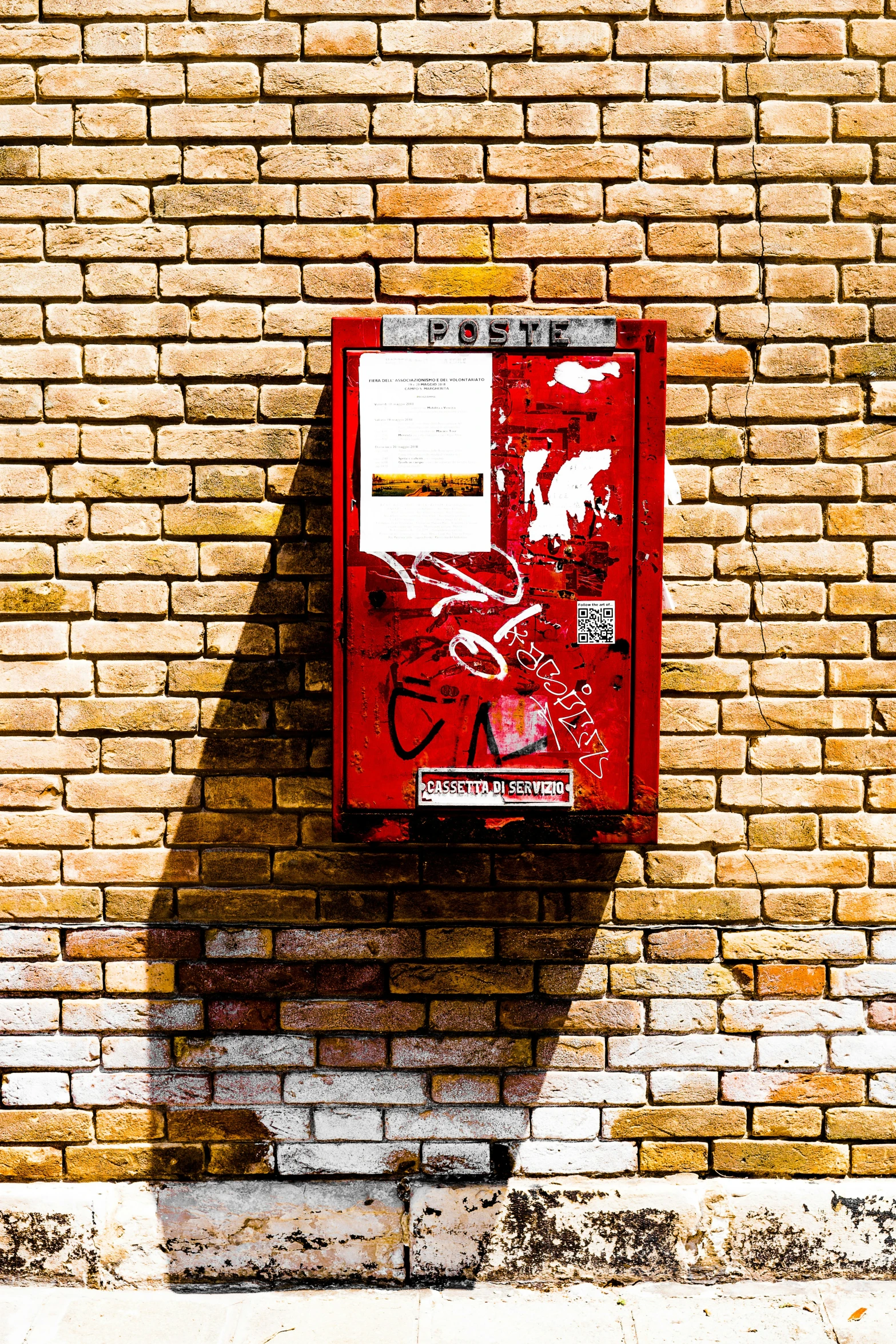 a red street sign next to a brick wall