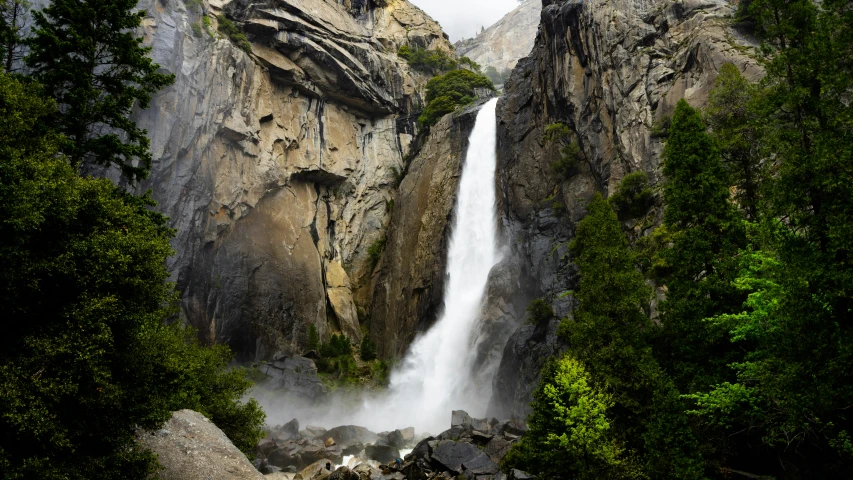 a tall waterfall with a waterfall surrounded by rocks