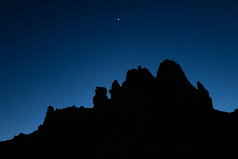 an airplane flies above some mountains against the evening sky