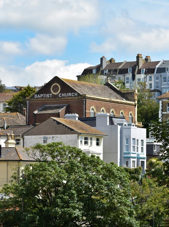 buildings line the foreground, next to tall, brick topped houses