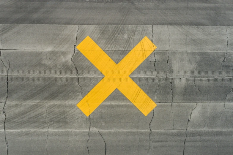 a yellow cross on an airplane wing