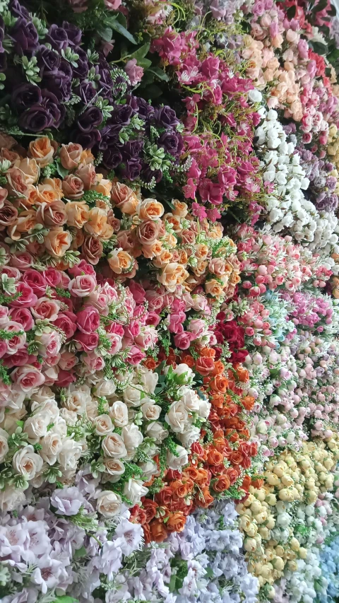 many colorful flowers are arranged on a wall