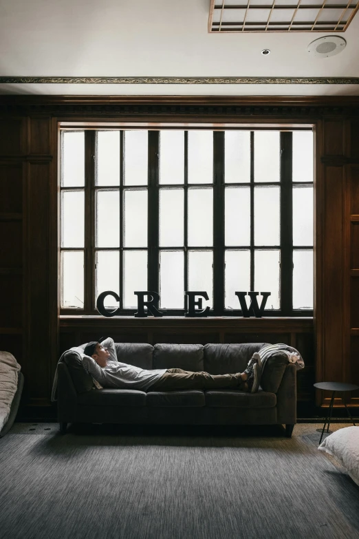 an empty couch is against a large window