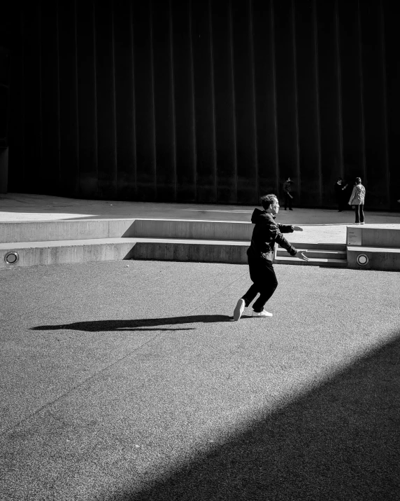 a person riding a skateboard across a paved area