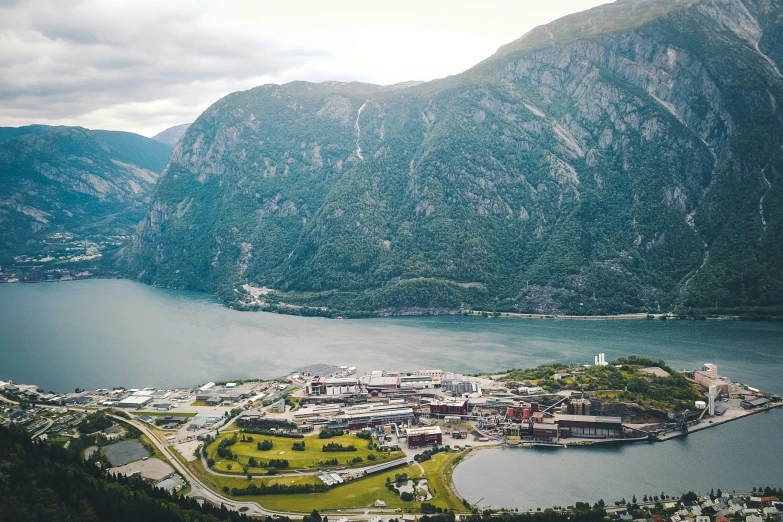 a large mountain is beside the city with a lake and town