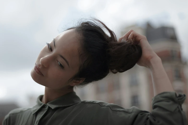 a young asian woman holds her hair in her hands