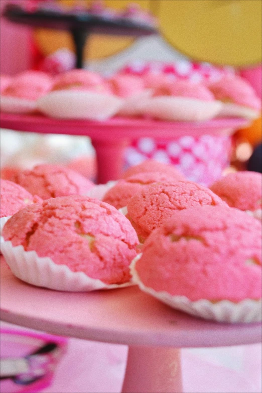some pink cupcakes are sitting on a table