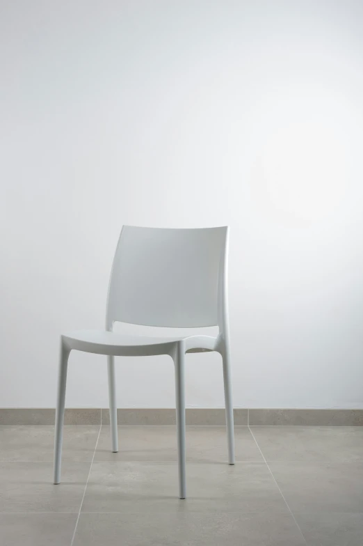 white plastic chair sitting on the floor in a room