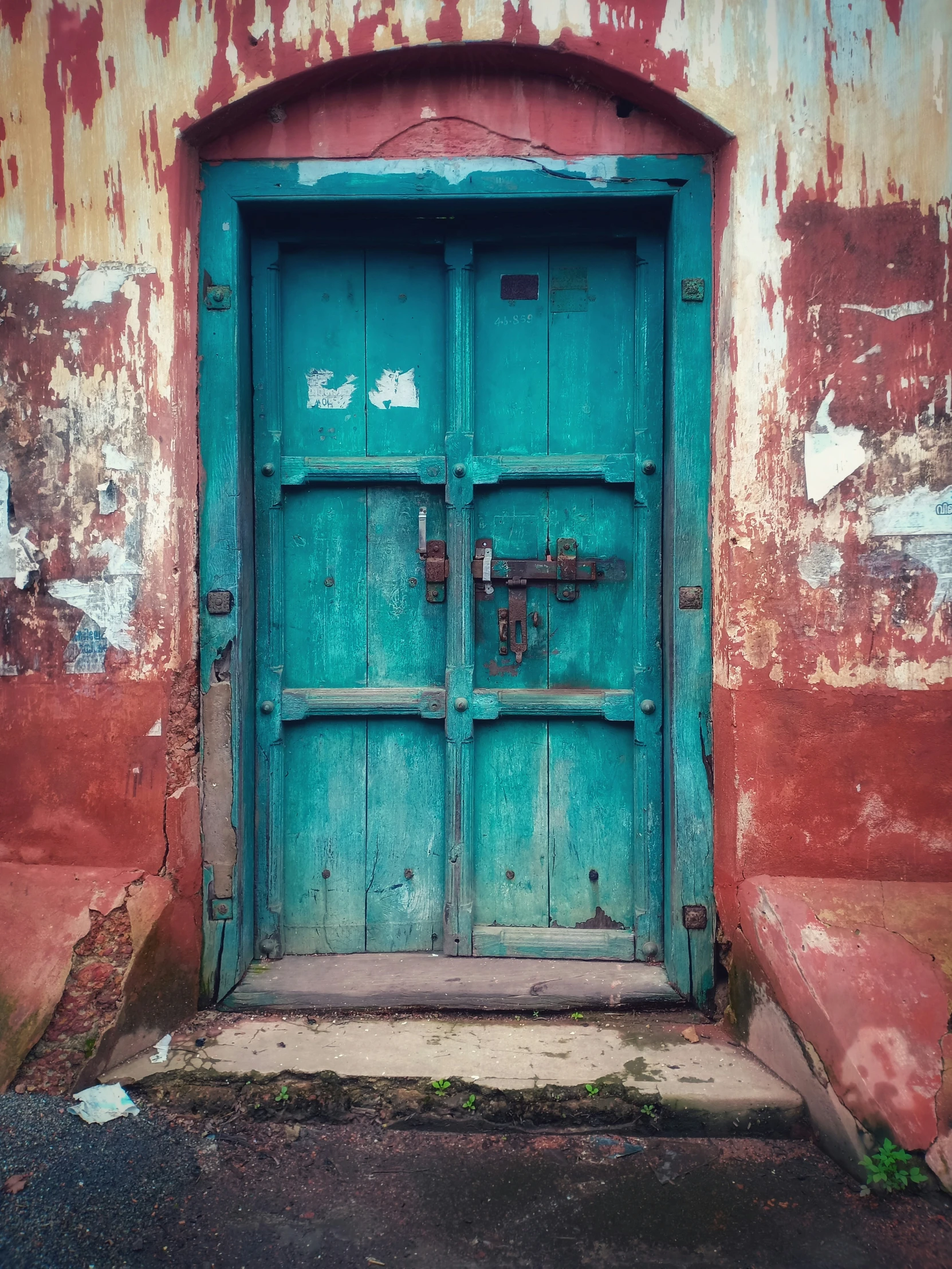 an old building has two doors and rusty paint