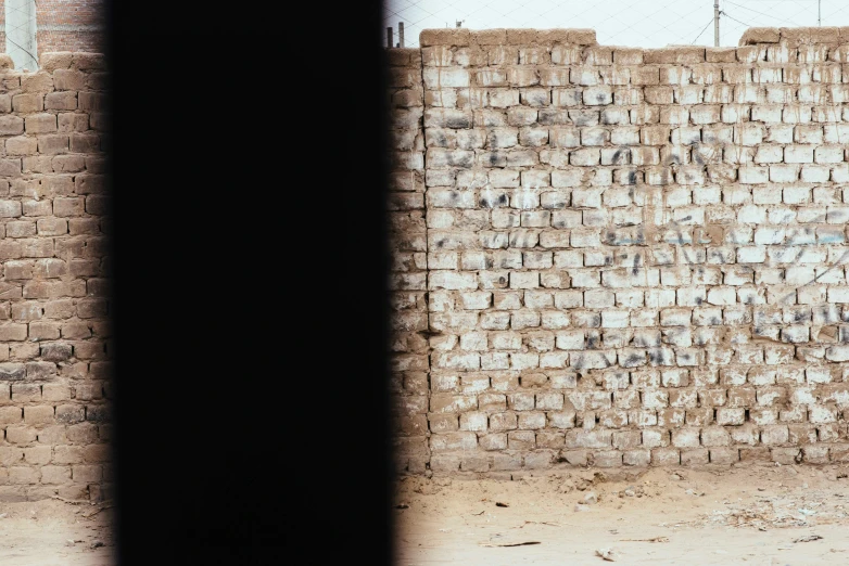 a young child walks by a brick wall