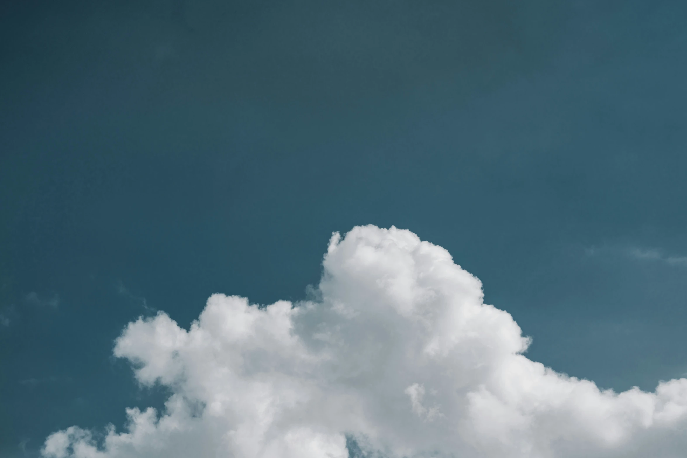 airplane flying on a cloud filled sky during the day