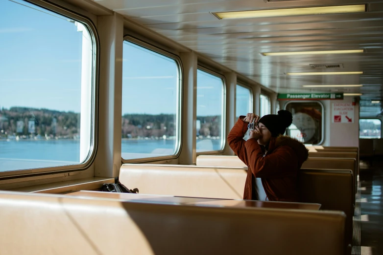 a girl is talking on the phone while riding a boat