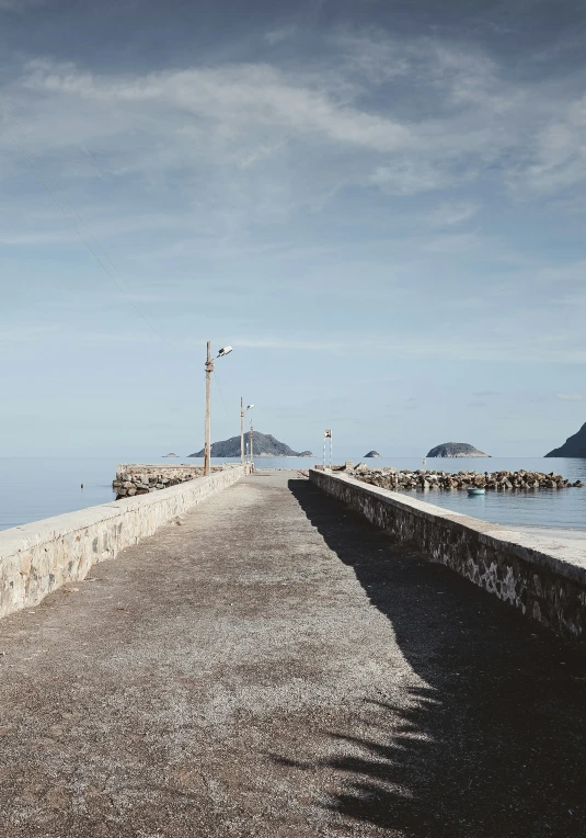 the road next to the water runs across a concrete wall