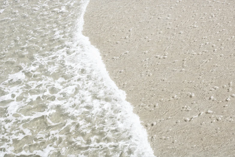 the view of waves on the beach from the sand