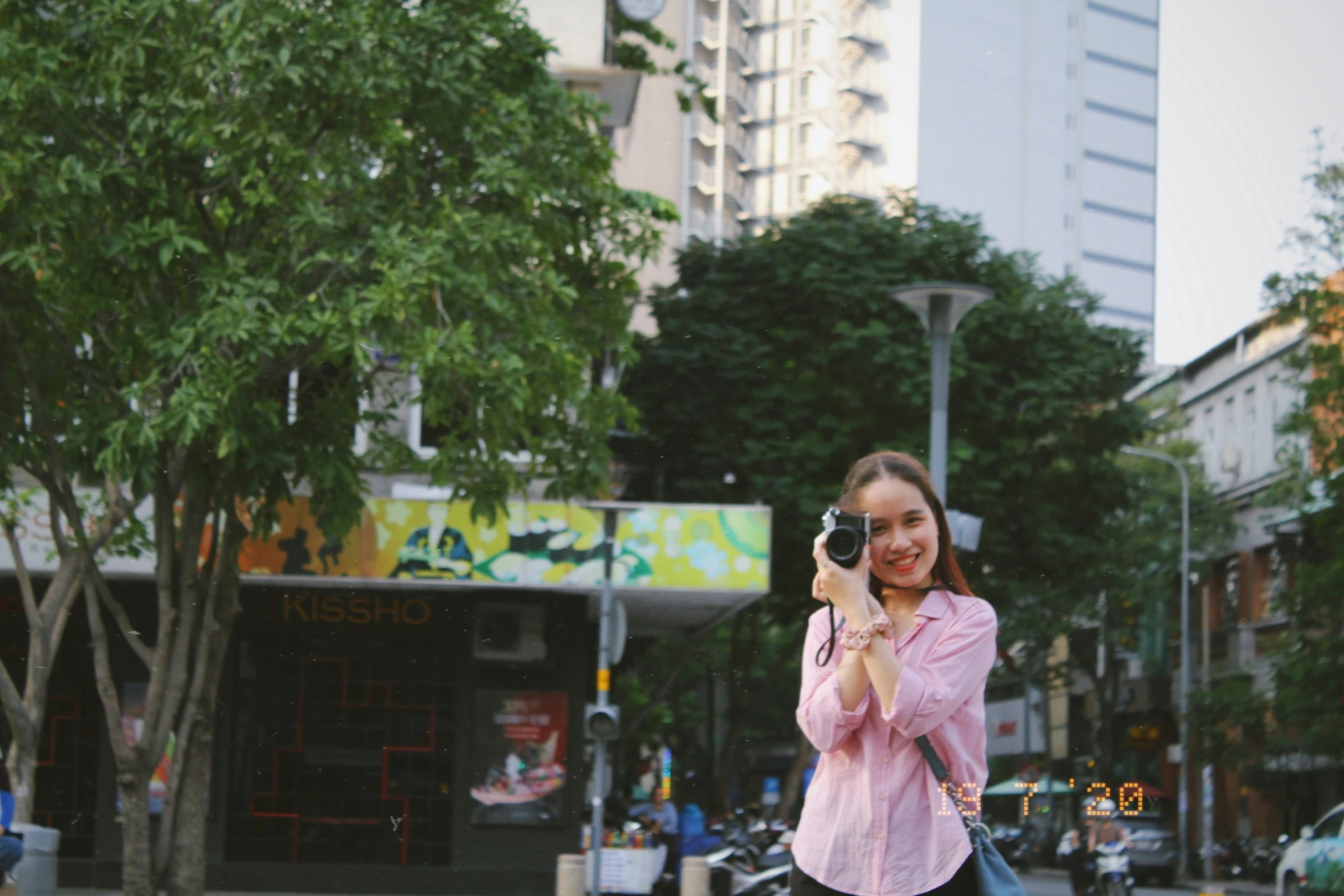 a woman taking a selfie on a city street