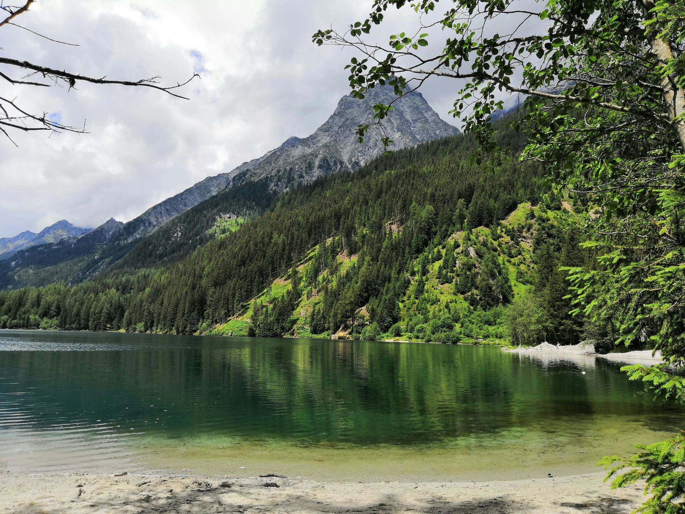 green water surrounded by mountains and trees