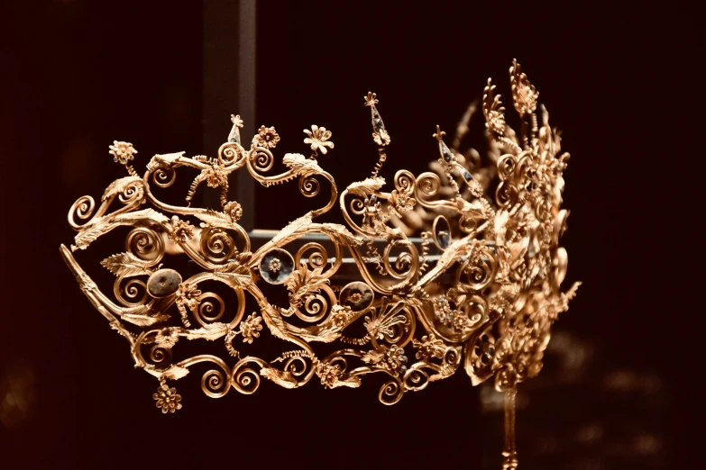 a golden ornate crown is sitting on a black surface