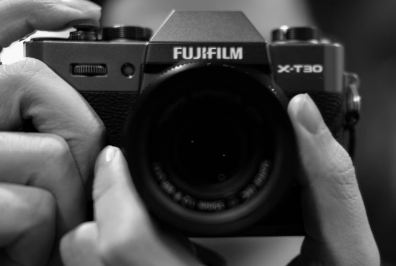 black and white pograph of a person holding a digital camera