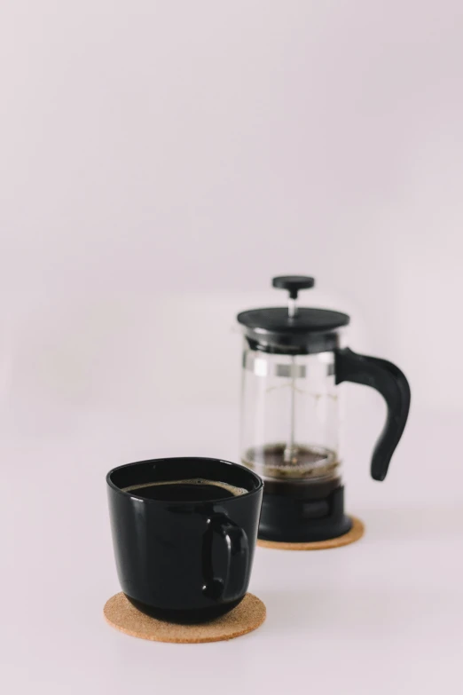 two coffee mugs sit on cork coasters