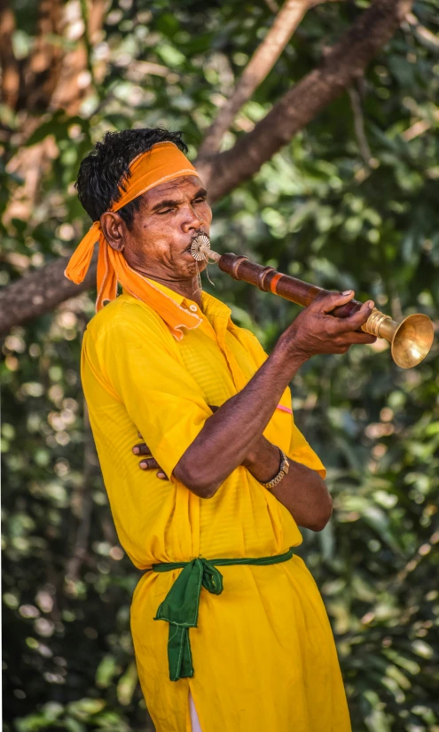 an old man dressed in yellow and playing an instrument