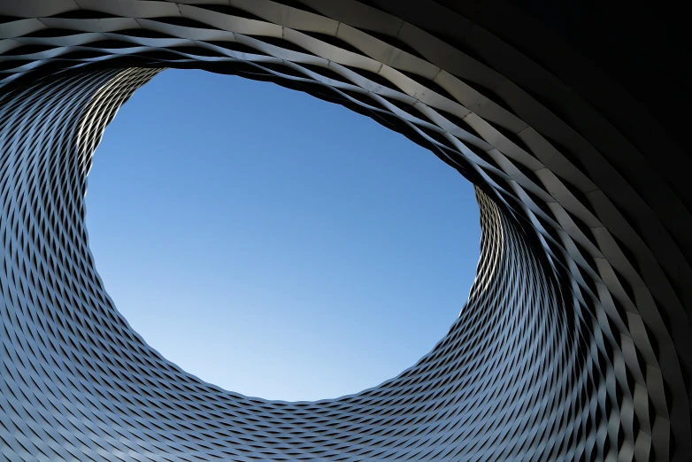 a circular sculpture with buildings in the background