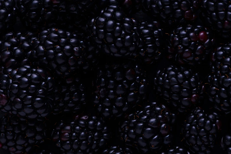 a large bunch of blackberries laying on a surface