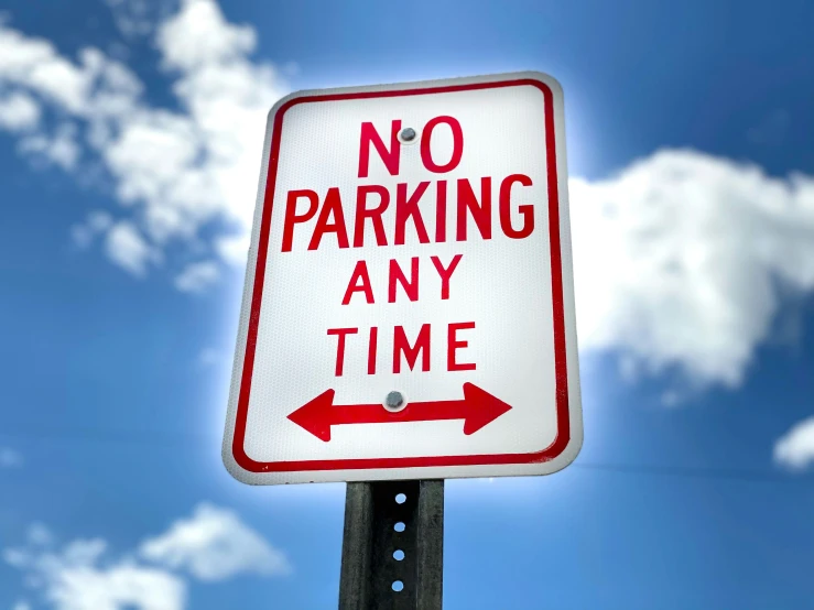 a sign is posted near the sky with clouds in the background