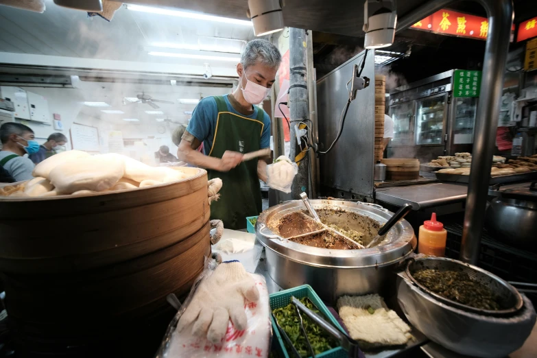 a man in an apron and some food behind a counter