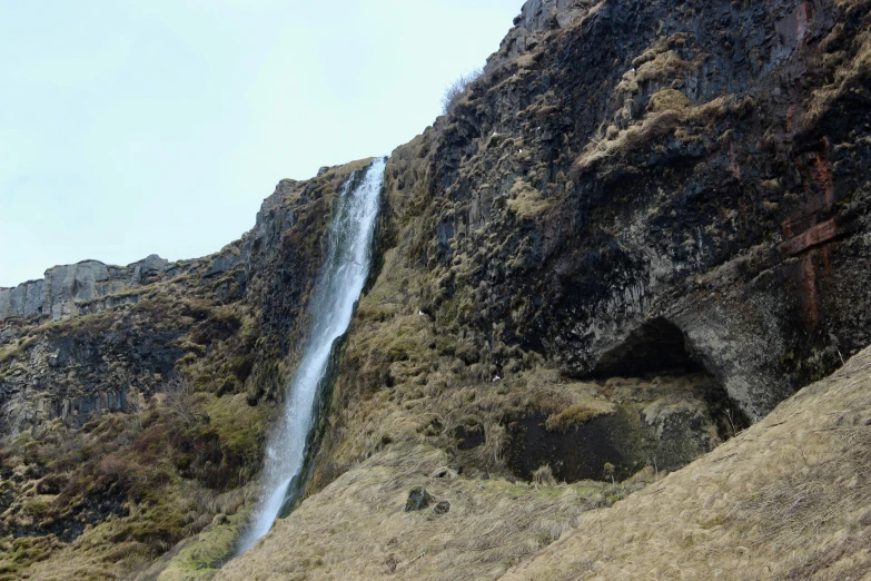 this is a large waterfall coming from behind a mountain