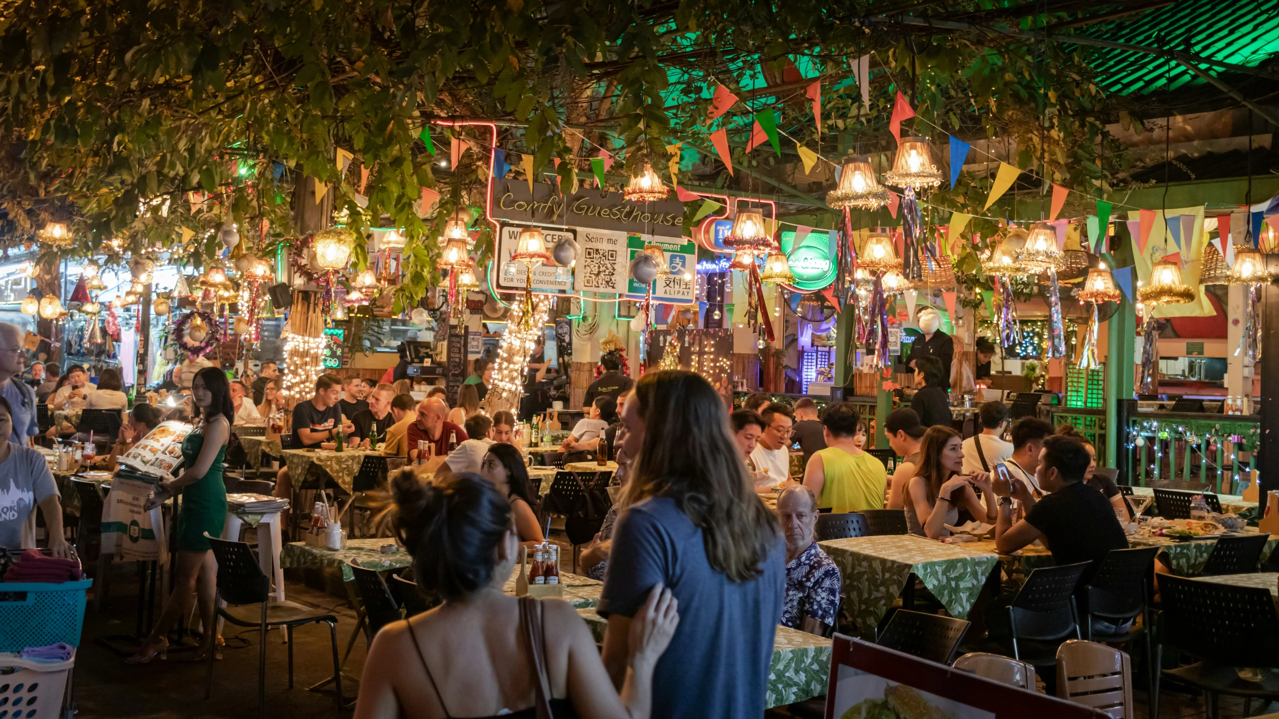 a crowd is gathered in a crowded cafe for a dinner