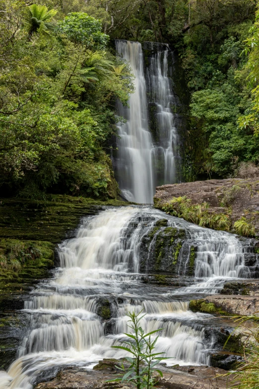 a tall waterfall with a tall pool of water