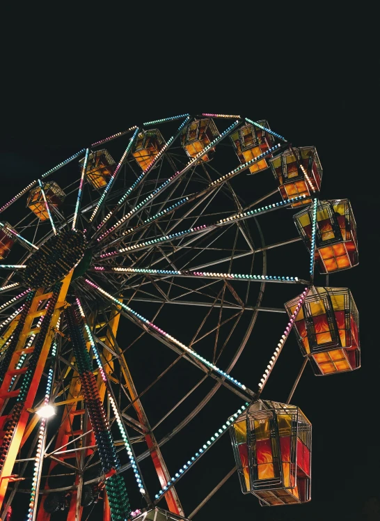 a fair is lit up at night with colorful lights