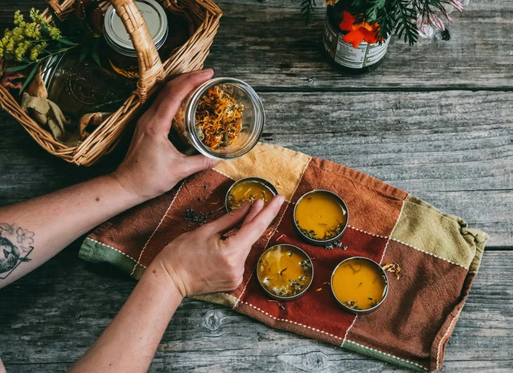 a person is holding a cup of mustard to their food