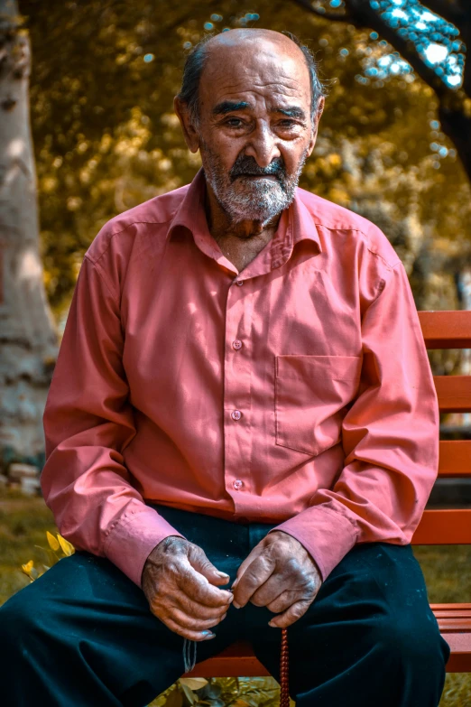 a man sitting on a park bench next to trees