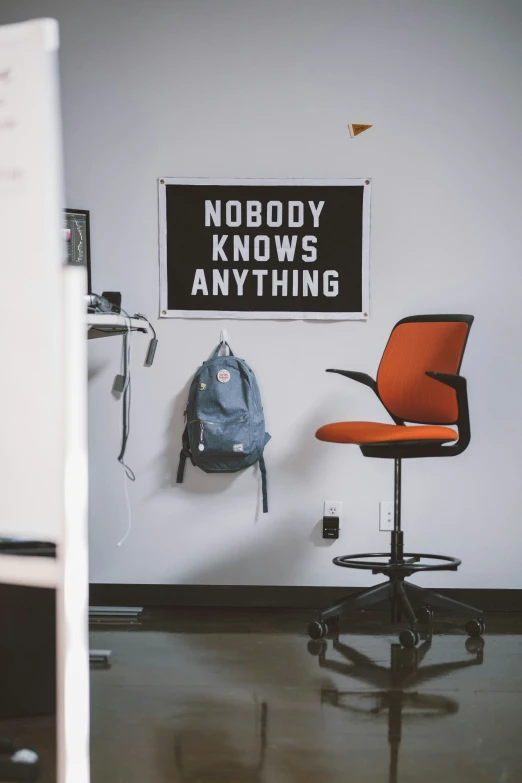 a chair, bag, and book bag hanging up on a wall